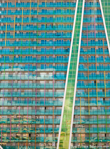 A glass facade on an apartment building in blue, green, pink, orange and yellow in Tirana, Albania