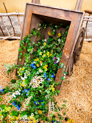 A wooden cart flowing with flowers and plants displayed at an Easter Market in Prague, Czech Republic.