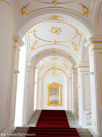 The main stairwell in the Bratislava Castle is adorned with gold trimmings and red carpetting.