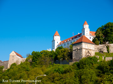 On a sunny day, the Bratislava Castle shines on the hilltop, overlooking the city