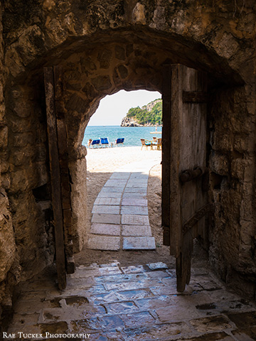 Old, wooden doors open from the Stari Grad to the beach in Budva, Montenegro
