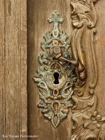 An antique door handle on a wooden door