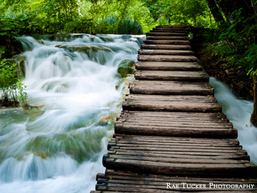 A wooden boardwalk surrounded by flowing water in Plitvice National Park in Croatia