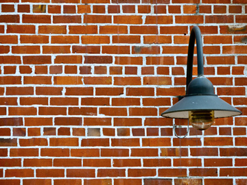A black, industrial light on a brick wall in Vancouver, Canada