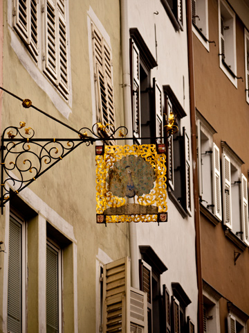 Windows and a golden sign in Bolzano, Italy