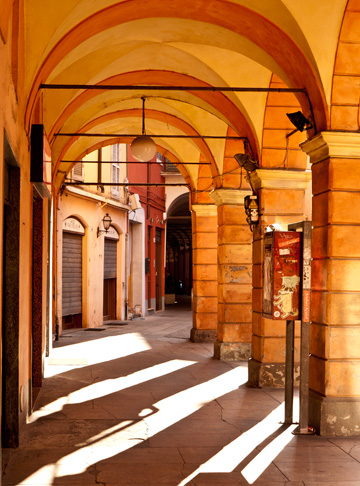 The sun filters through a portico in Modena, Italy