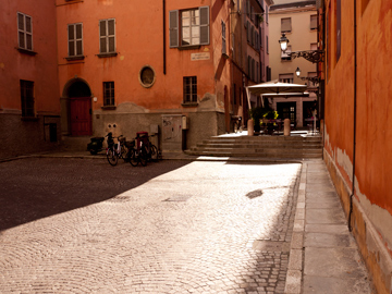 A small square illuminated by the late afternoon sun in Parma, Italy
