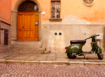 A vespa and wooden door in Parma, Italy