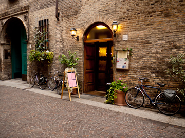 A street in Parma, Italy with plants, doors and bicycles