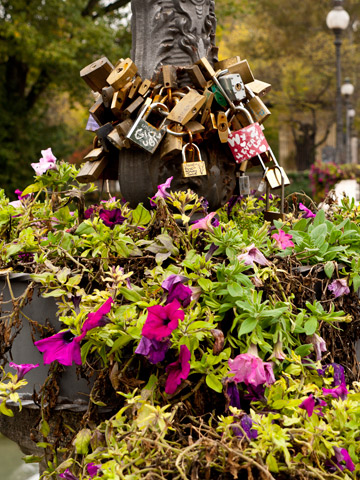 A street light in Parma, Italy is adorned with flowers and locks