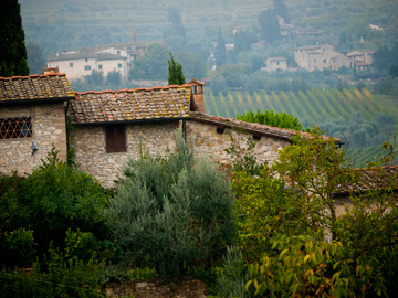 A stone building on a hill overlooking Tuscany