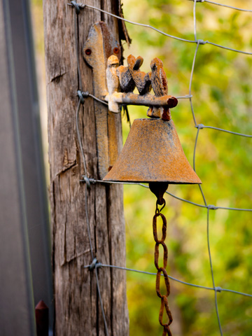 A rusted bell welcomes visitors in Tuscany, Italy