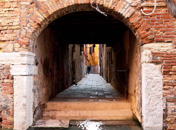 A brick tunnel emerging from a canal in Venice, Italy
