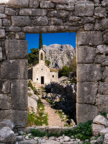 The ruins of Saint John church can be seen through an old door way made of rocks in Kotor, Montenegro.