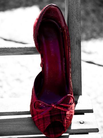 A red, plaid shoe stands out against the black and white background.