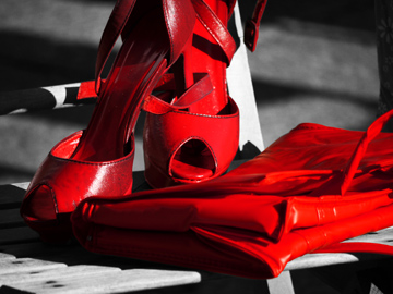 Red shoes and a red purse on a black and white background