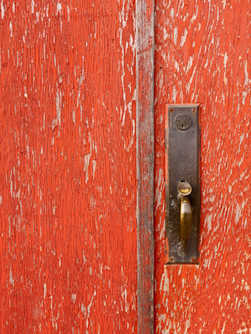 The artful peeling of red paint on the door.