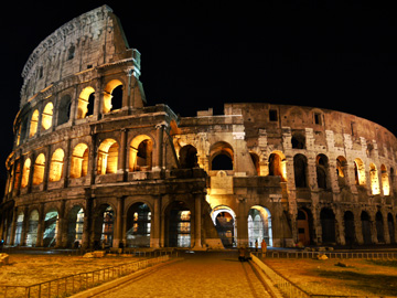 Roman coliseum lit up at night in Rome, Italy