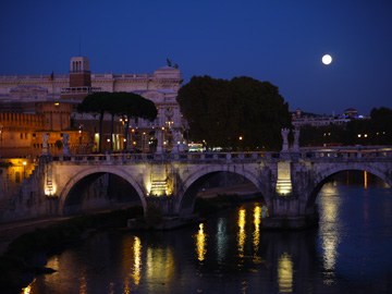 Ponte Sant'angelo on the Tiber river under the light of the full moon in Rome, Italy.