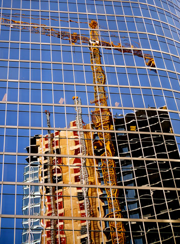 Downtown skyscraper construction reflected in a glass building in Vancouver, BC