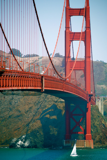 A sail boat sailing under the Golden Gate bridge in San Francisco, California, Canada