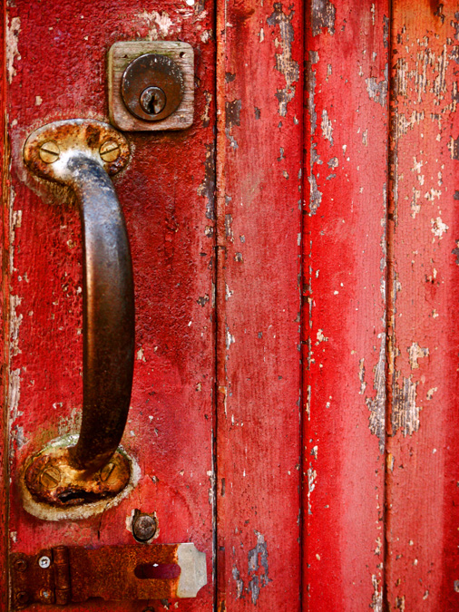Red shed door with a rusted handle