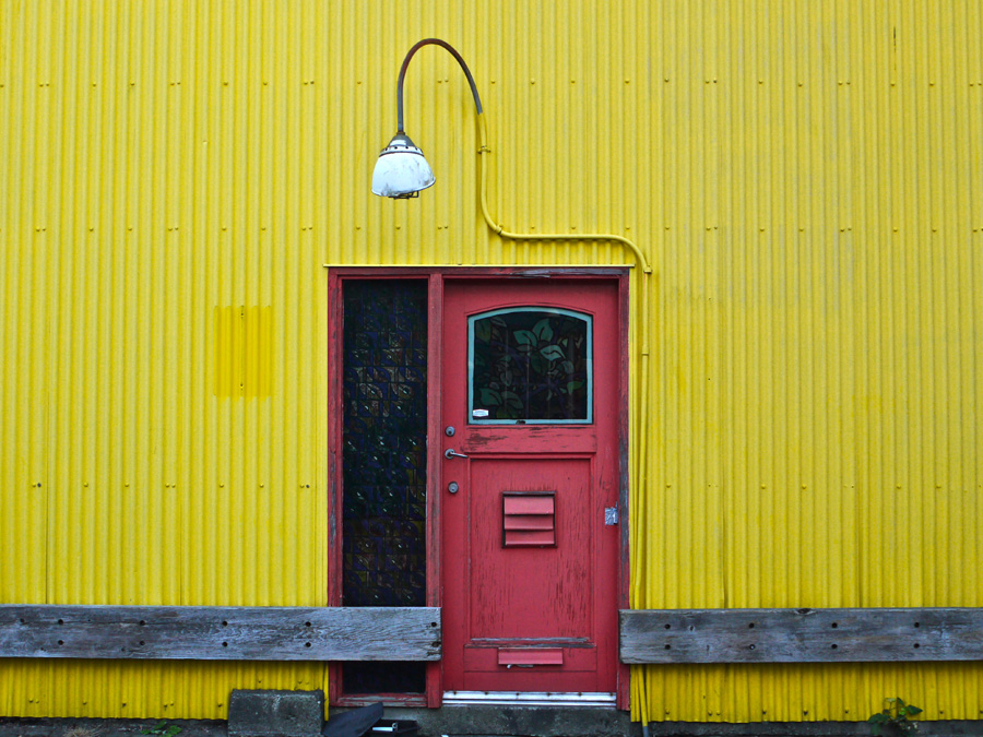 A red door on a yellow wall on Granville Island in Vancouver, British Columbia
