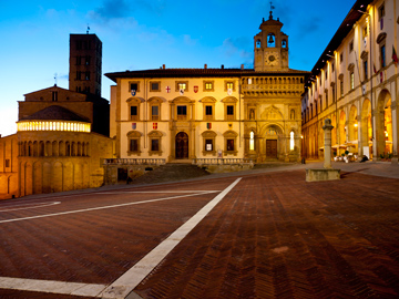 The buildings of Piazza Grande aglow at dusk in Arezzo, Italy