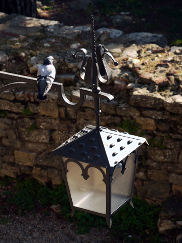 A pigeon is perched on a lantern in this small park in Arezzo.